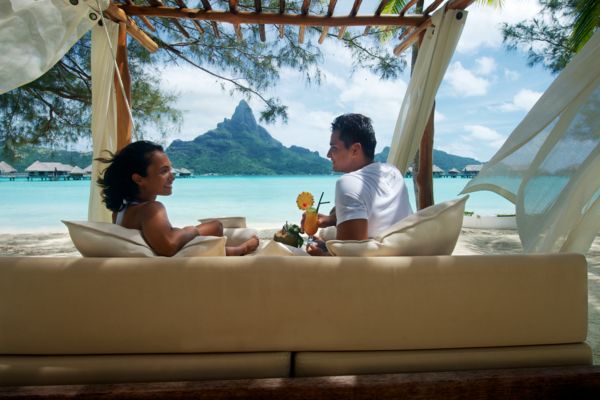 couple in front of Bora Bora island taking on the beach